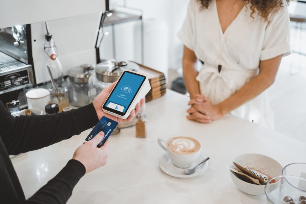 4 Ways Of Using Your Credit Card Wisely While Travelling Abroad woman standing and holding smartphones