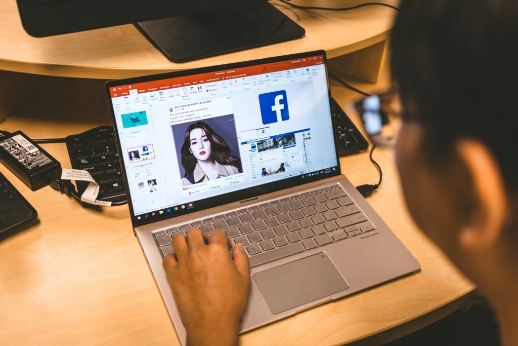 How To Use Facebook Fan Pages To Advertise Your Real Estate Business person using laptop browsing facebook application