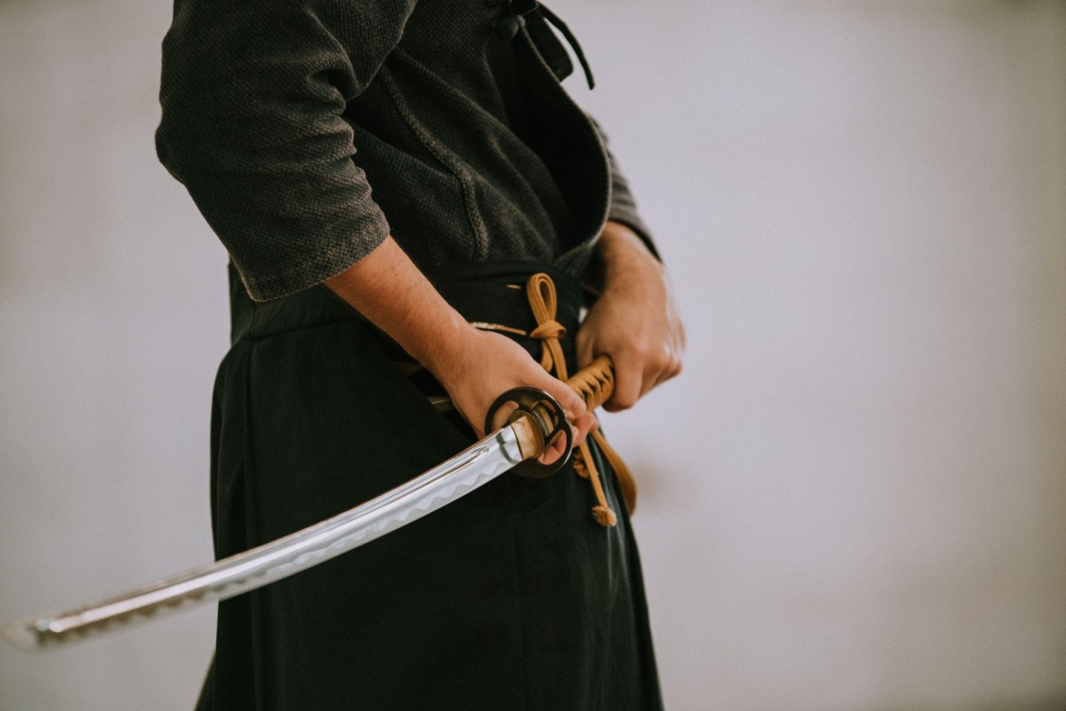 The Exciting History Of Japanese Samurai Swords That Will Leave You Thinking person in black long sleeve shirt and black skirt holding white leather belt