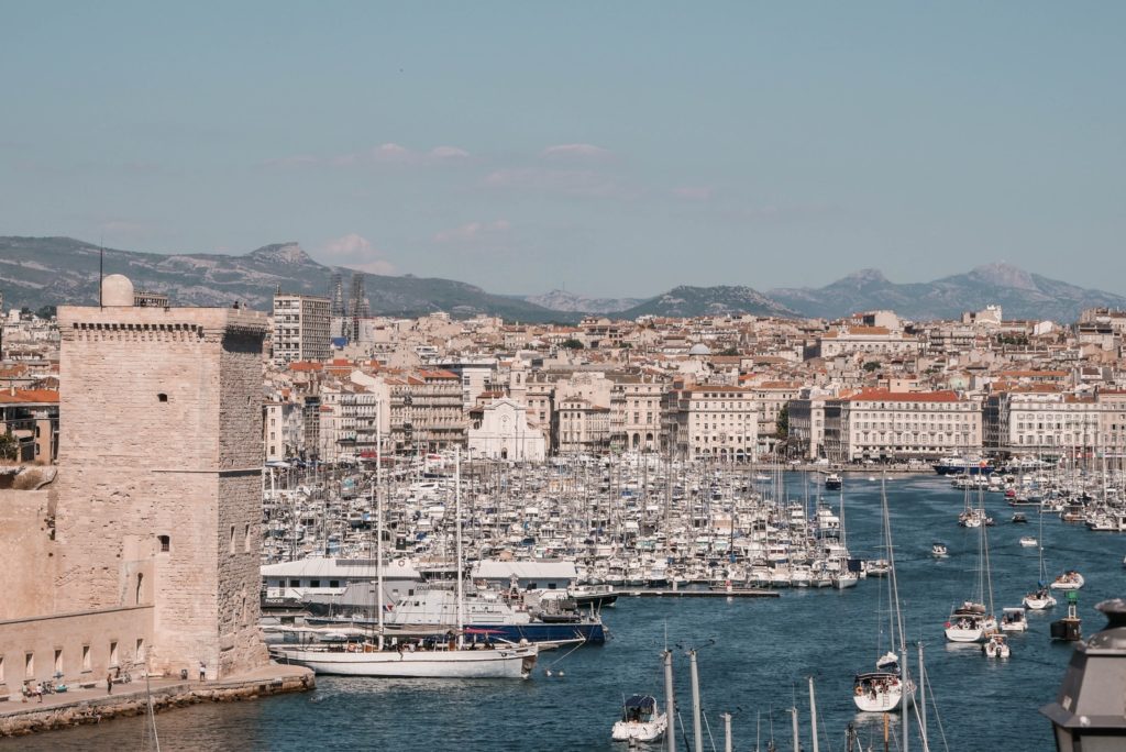 5 Unique Things To Try In Marseille! white and blue boat on sea near city buildings during daytime