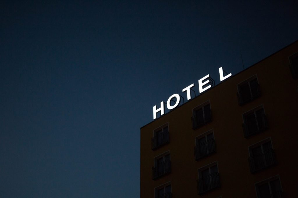 Our Top Tips For Saving Money On Airport Hotels low-angle photo of Hotel lighted signage on top of brown building during nighttime