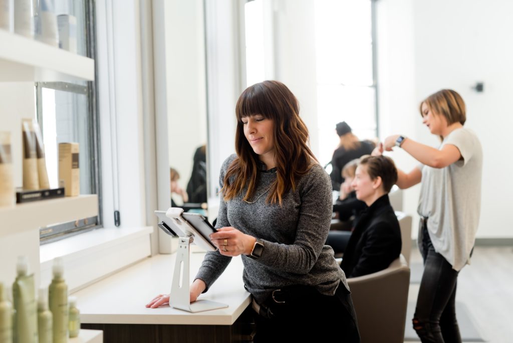 4 Tips For Choosing The Best Sweater and Quality Jumpers woman in gray sweater holding tablet computer