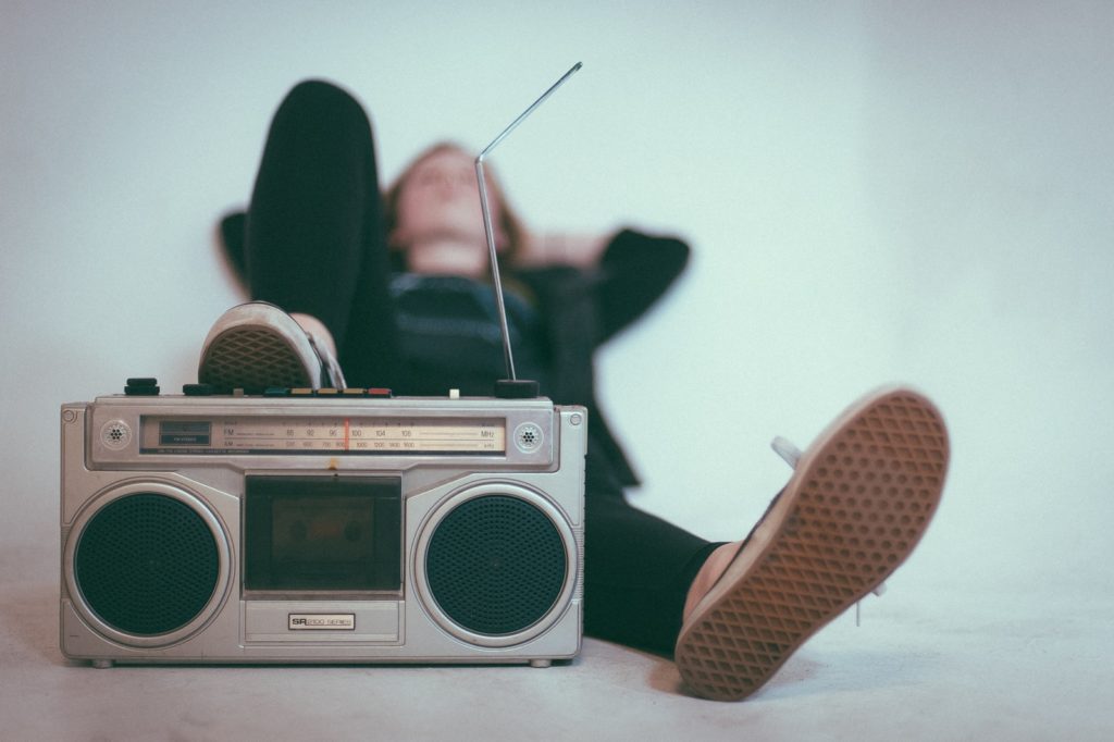 How The Music Industry Can Stave Off Menaces Of Piracy & Declining Sales woman laying on bed near gray radio
